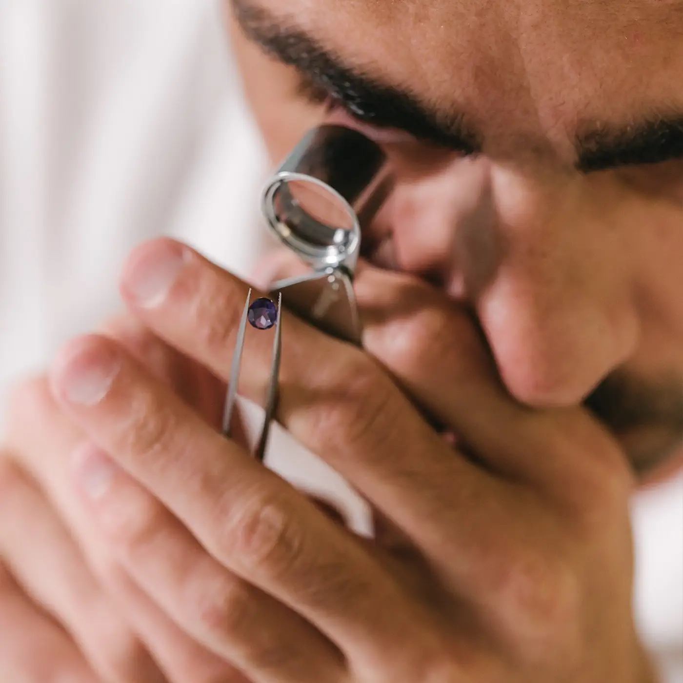 Gemmologist examining the clarity of a round amethyst