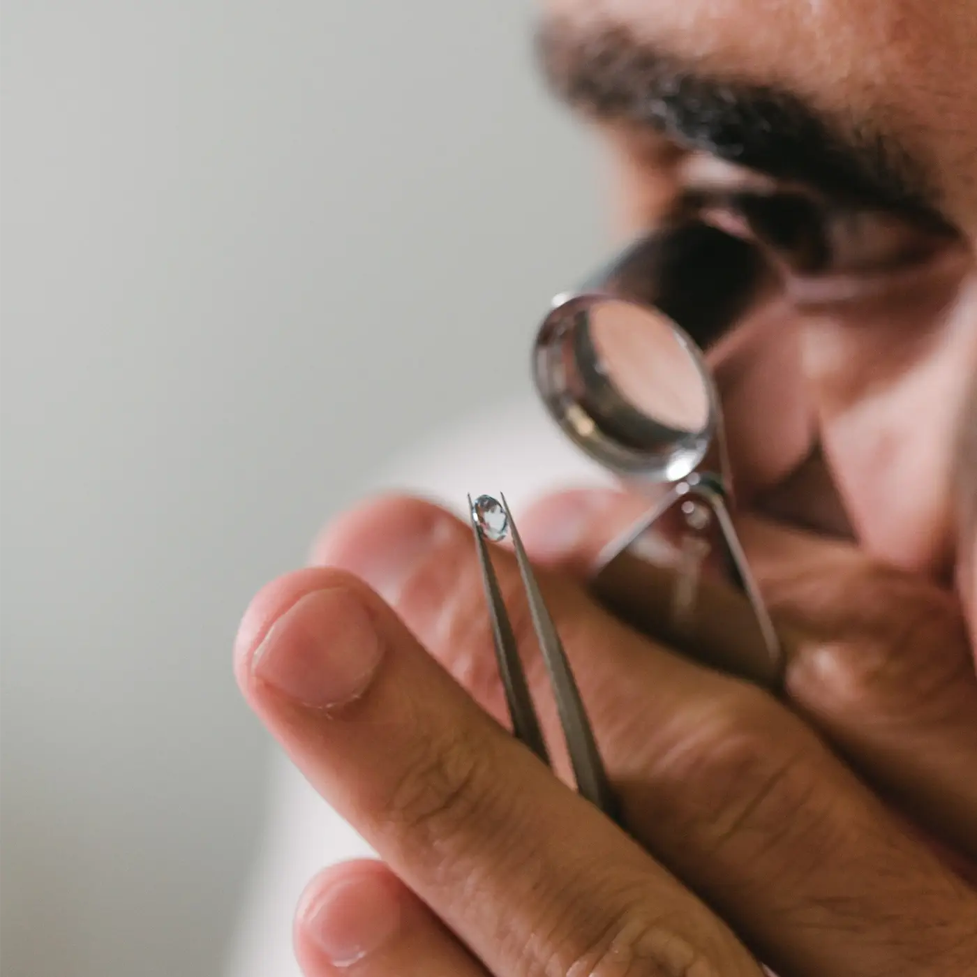 Gemmologist examining an oval aquamarine