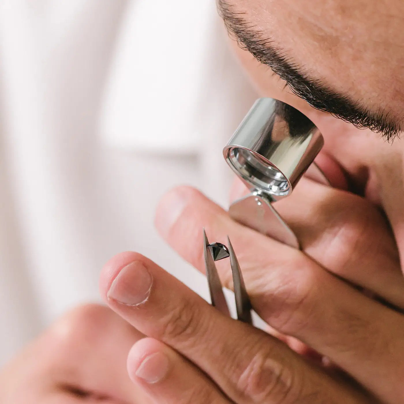 Gemmologist examining a round black diamond