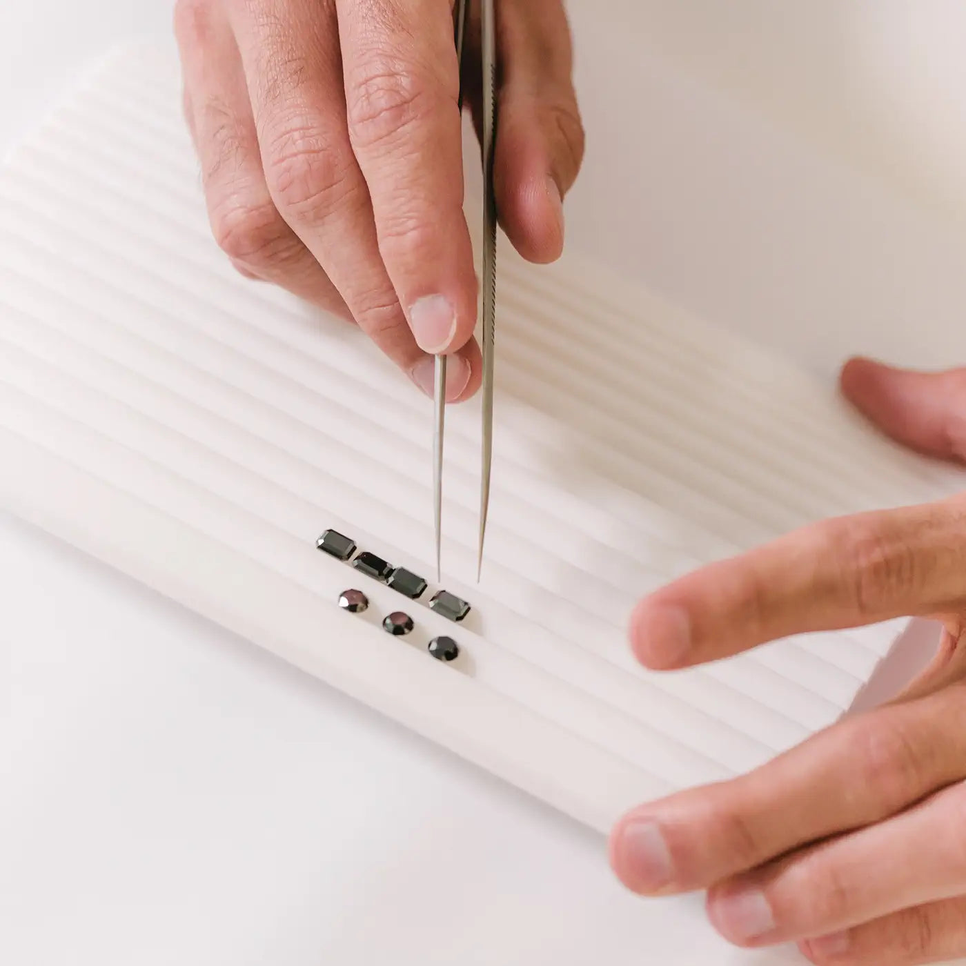 Round and Emerald cut black diamonds lined up in a tray