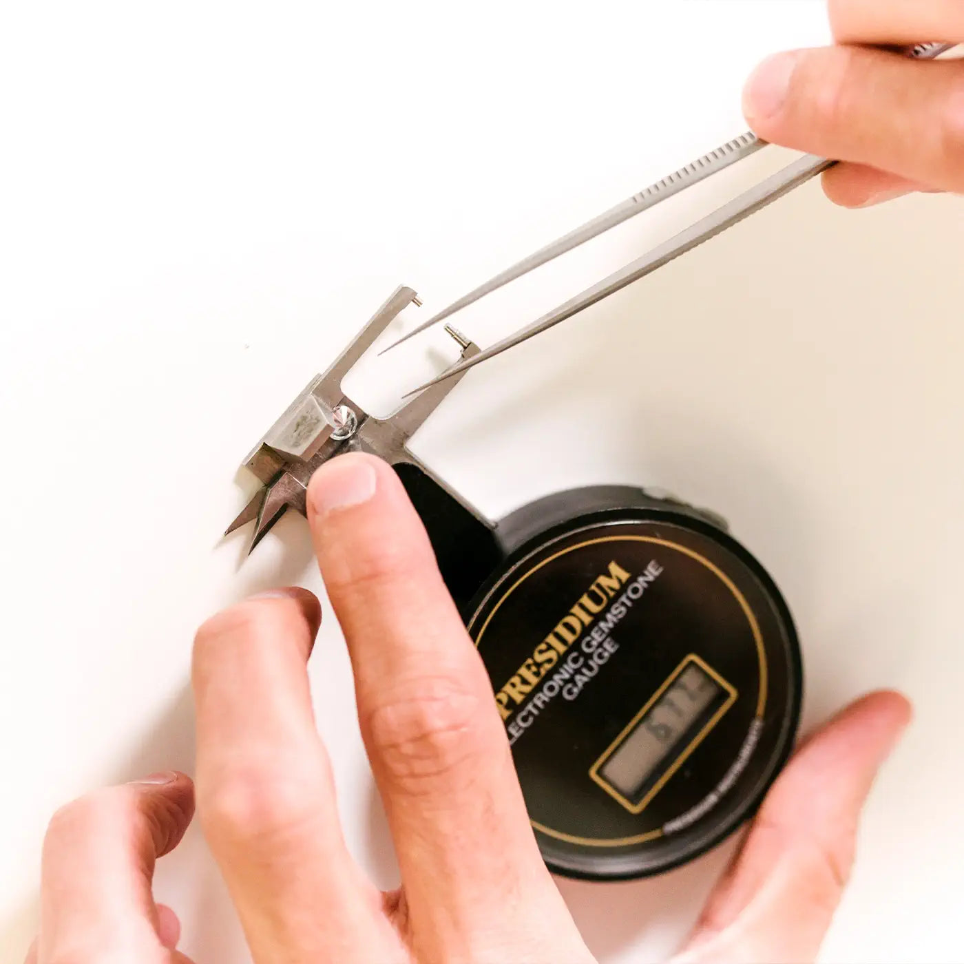 A round diamond being measured in an electronic gemstone gauge