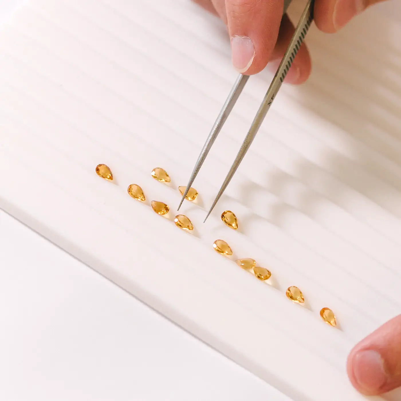 Selecting a line of Pear Citrines for a bracelet