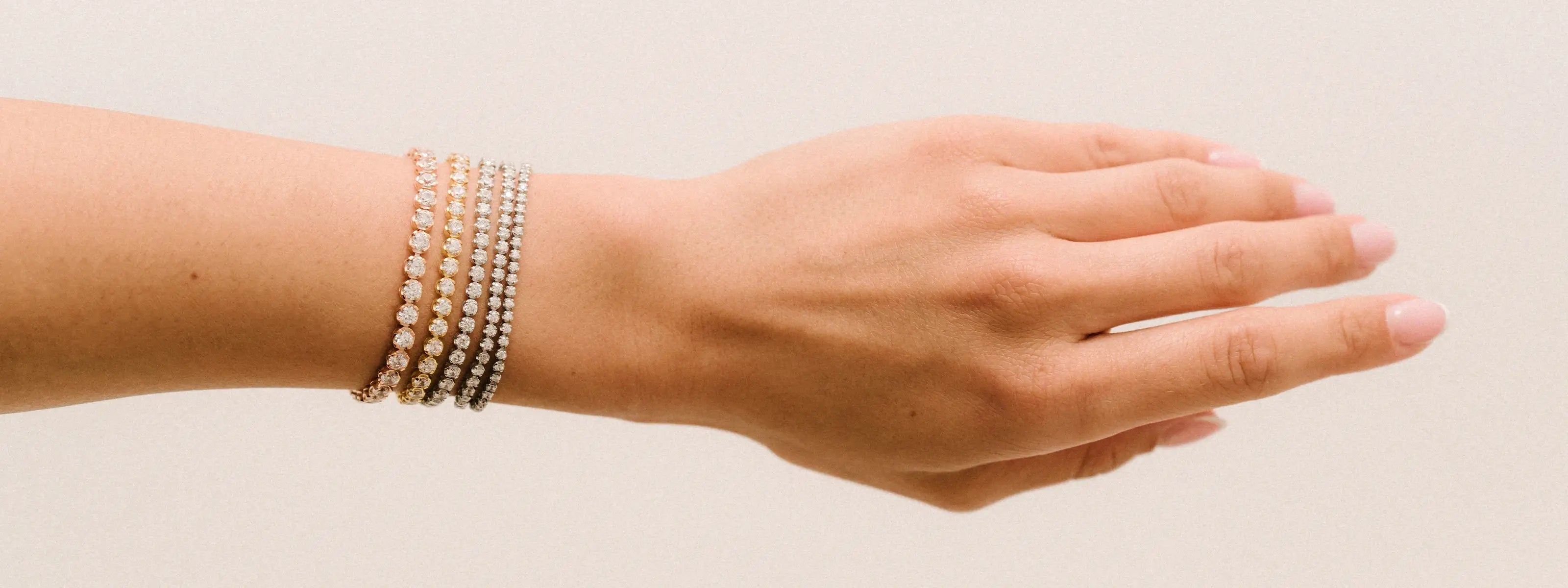 Multiple tennis bracelet in different sizes being worn on a wrist